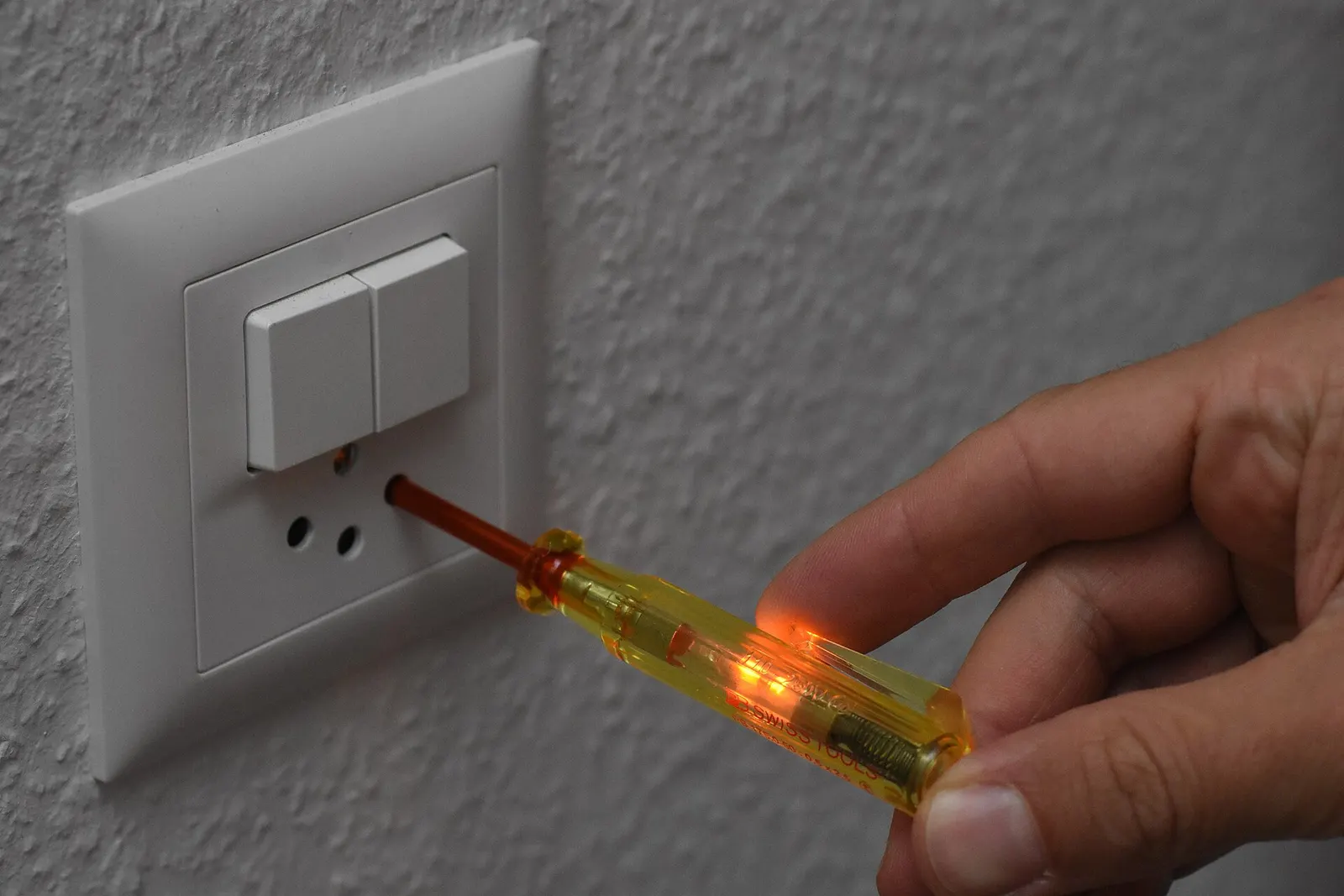 Zkoušečka zasunutá do zásuvky svítí, obvod je pod napětím